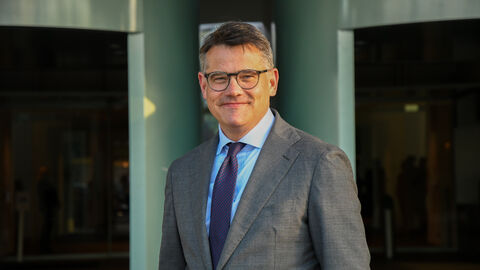 Ministerpräsident Boris Rhein steht vor dem Bundeskanzleramt und lächelt in die Kamera