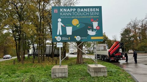 Plakat an der Autobahnauffahrt. Auf dem Plakat steht: Knapp daneben kann tödlich sein