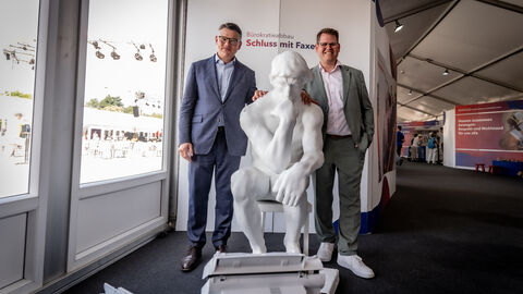 Ministerpräsident Boris Rhein und Bad Vilbels Bürgermeister Sebastian Wysocki stehen jeweils seitlich von einer weißen Statue. 