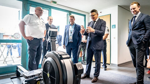 Ministerpräsident Boris Rhein begutachtet ein technisches Gerät. 