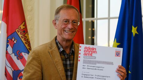 Staatsminister Axel Wintermeyer hält die Förderzusage in der Hand